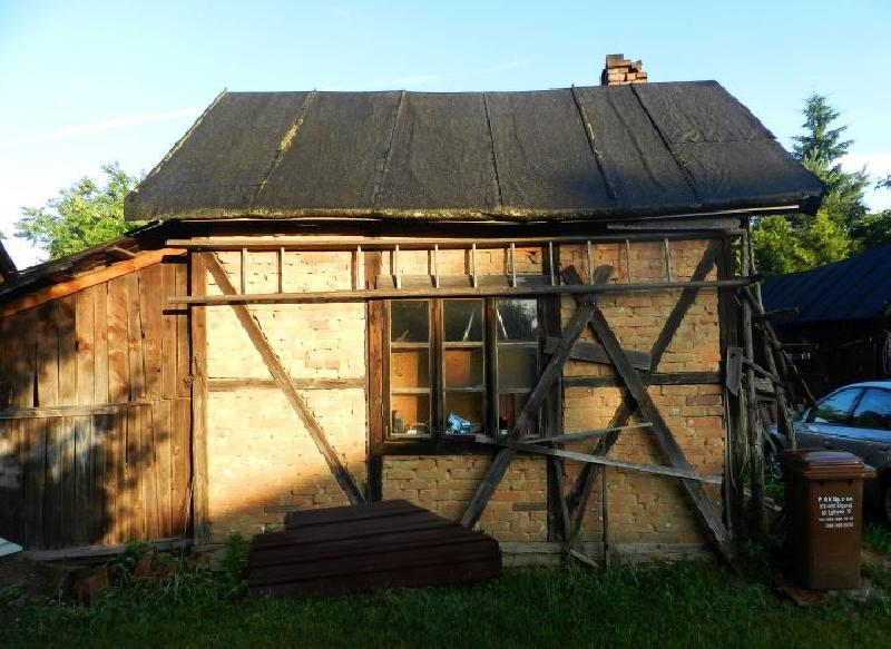 Stary ceglany domek z pojedyńczymi deskami i starym pojedyńczym oknem